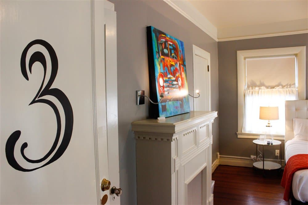 A cozy room featuring a fireplace, colorful artwork, and door number three.