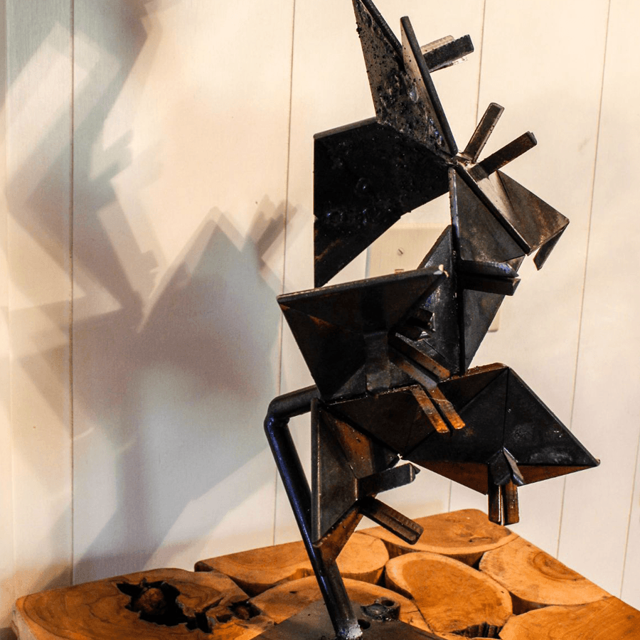A geometric metal sculpture casting abstract shadows on a wooden surface.