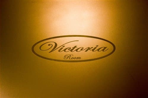 Sign reading "Victoria Room" in elegant script on a golden background.