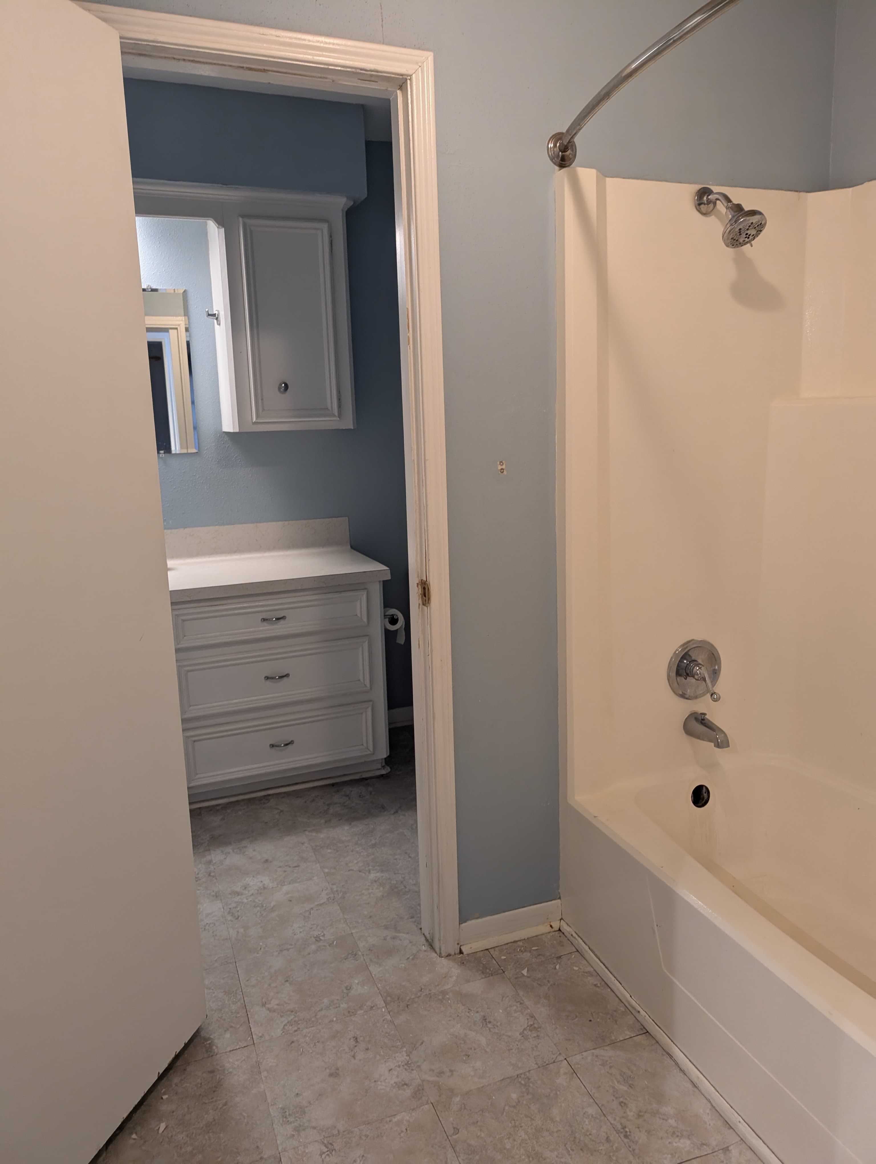 A bathroom featuring a bathtub, shower, and a white vanity with drawers.